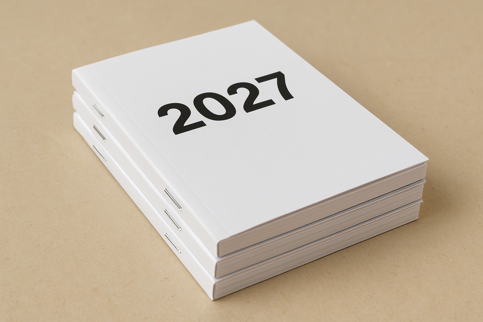 Stack of saddle-stitched 6 by 9.5 inch calendars with 2027 on the gloss cover