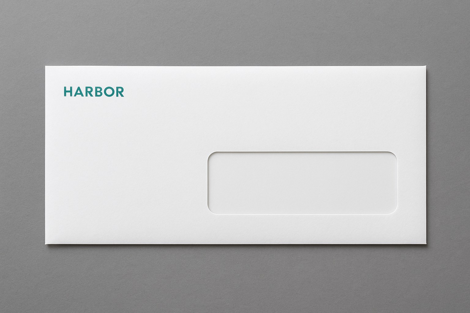Number 10 window envelope with a clear address window and an empty return corner on a gray desk