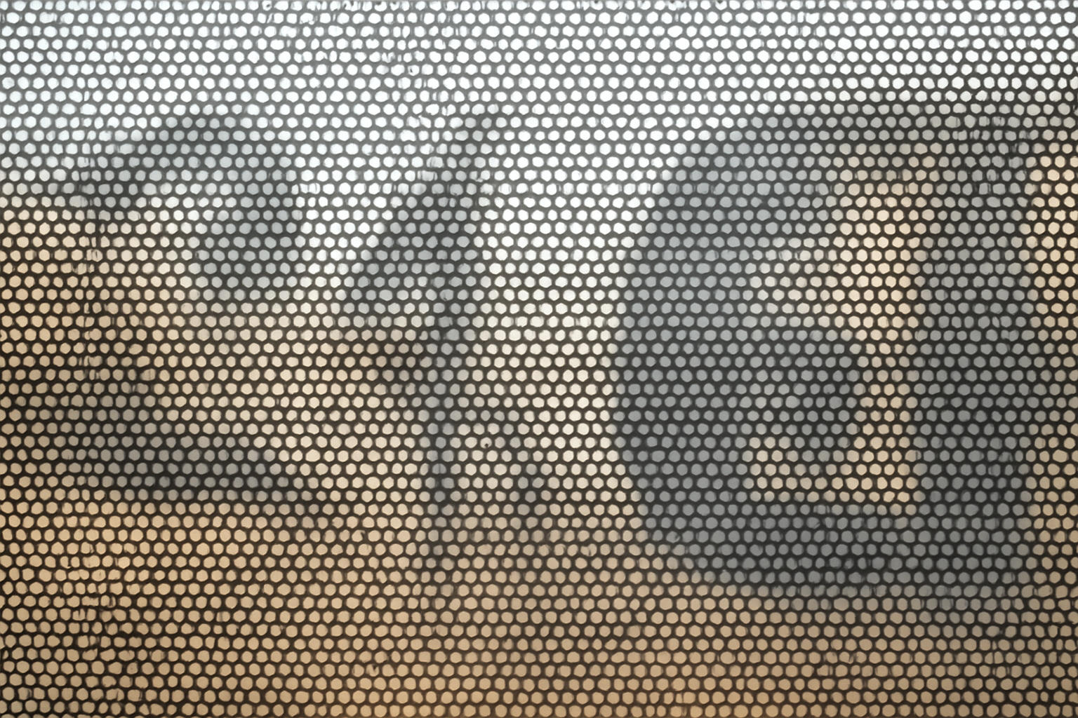 Close view of perforated window vinyl holes on glass so the inside still has a view out
